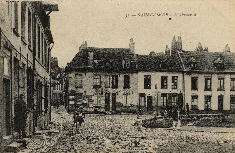 Cet abreuvoir situé dans le bas de la rue, juste avant l'enclos St Bertin, a aujourd'hui disparu, on se trouve dans un quartier ouvrier comme le montre les façades des maisons.